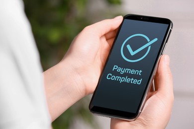 Woman successfully made payment using online banking application on smartphone indoors, closeup