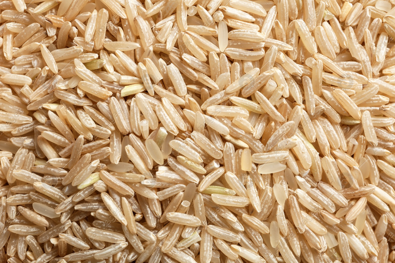 Photo of Raw brown rice as background, closeup view