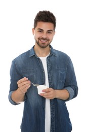 Photo of Happy young man with yogurt and spoon on white background