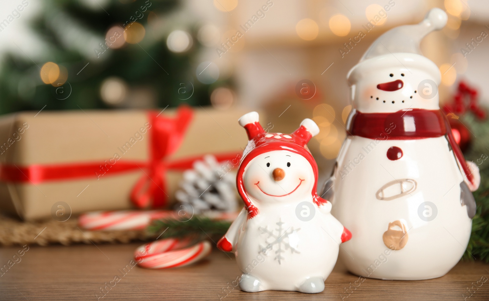 Photo of Christmas composition with decorative snowmen on wooden table, space for text