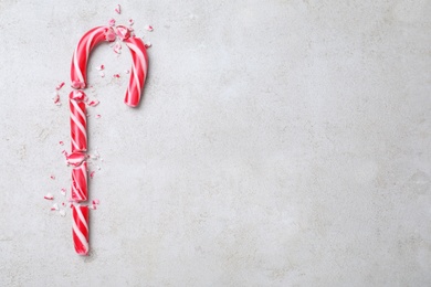 Photo of Crushed Christmas candy cane on grey background, flat lay. Space for text