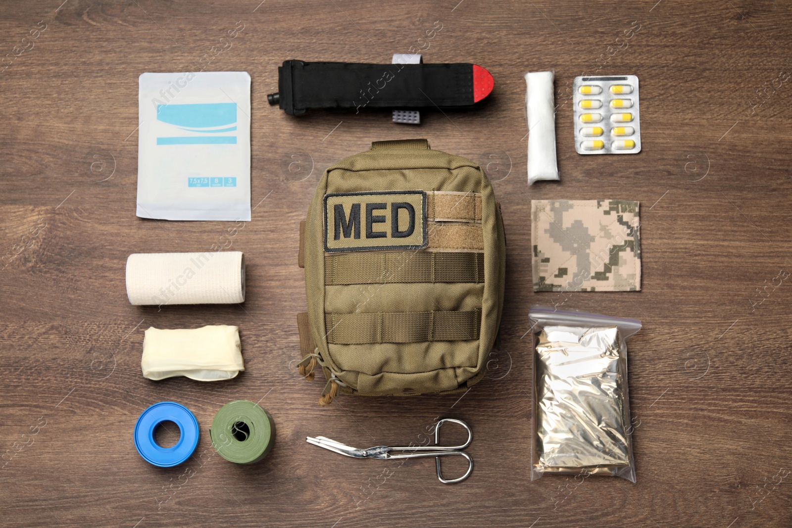 Photo of Military first aid kit on wooden table, flat lay