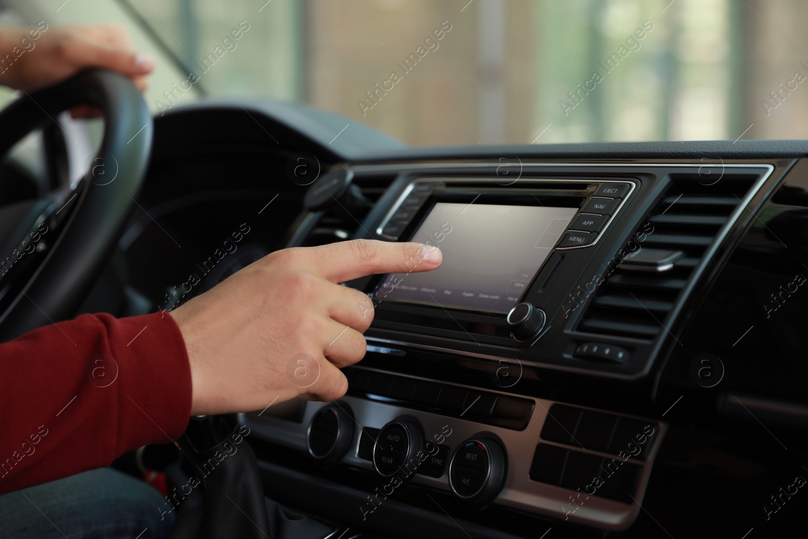 Photo of Man using navigation system while driving car, closeup