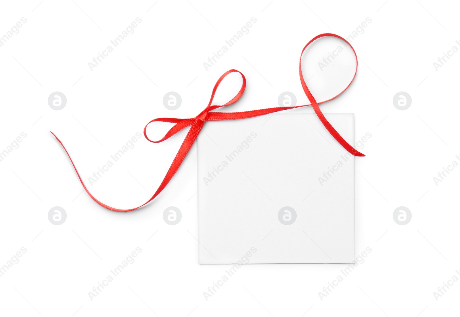 Photo of Blank gift tag with satin ribbon on white background, top view