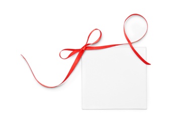 Blank gift tag with satin ribbon on white background, top view