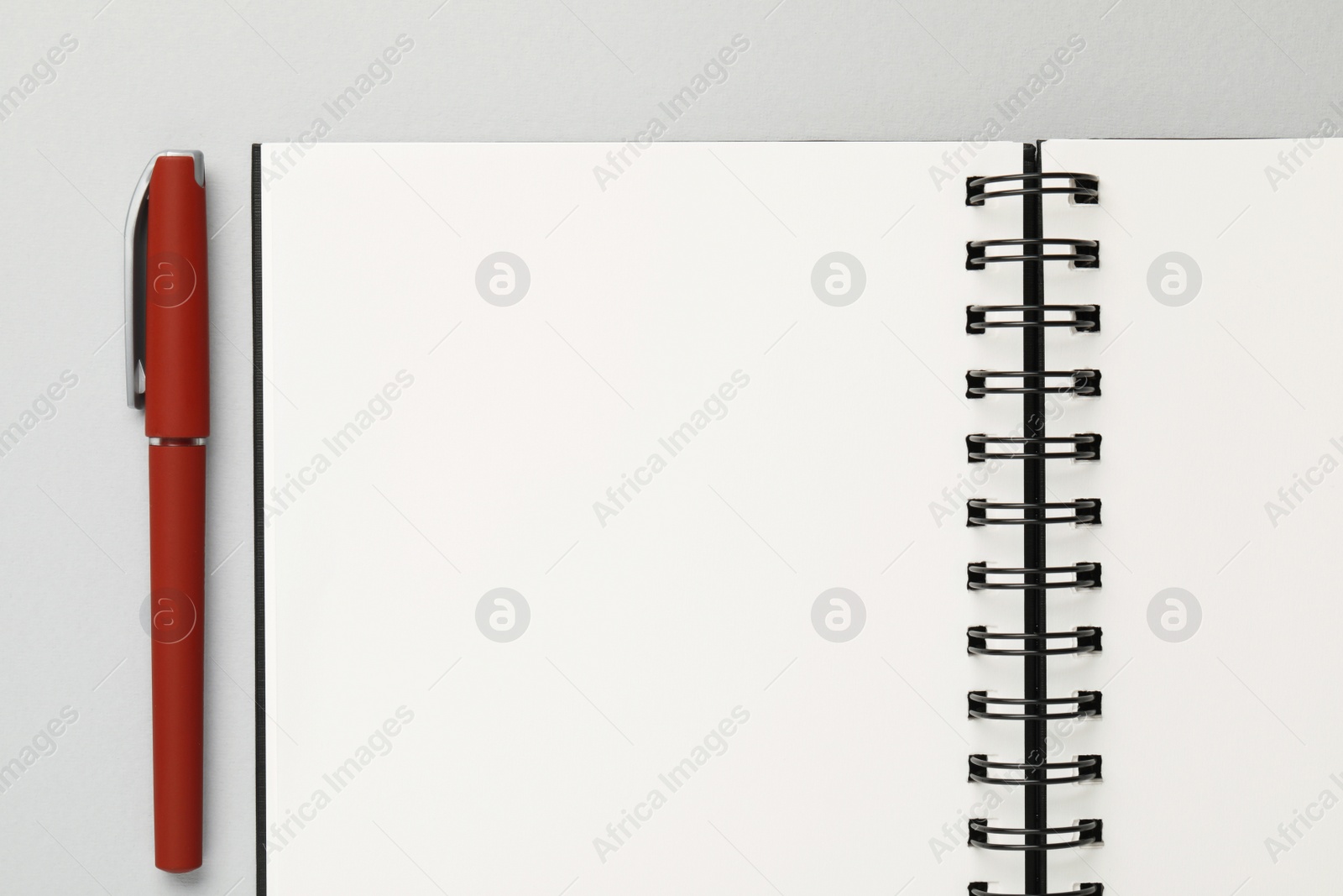 Photo of Notebook and pen on gray background, flat lay