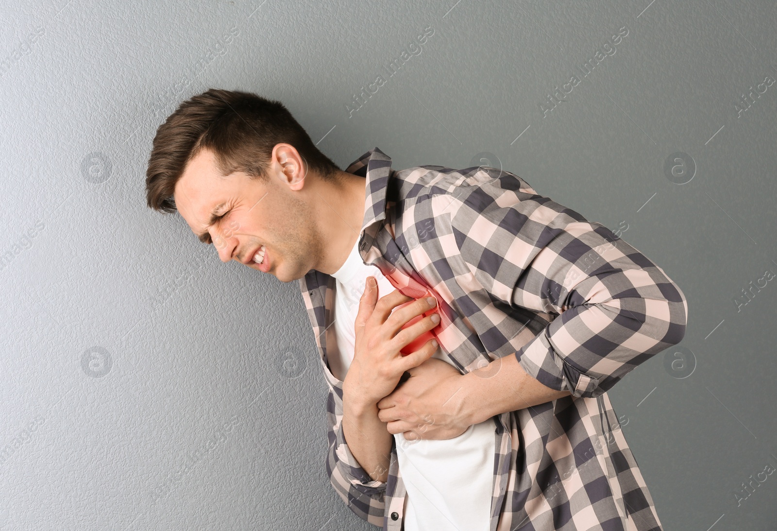 Photo of Young man having heart attack on color background