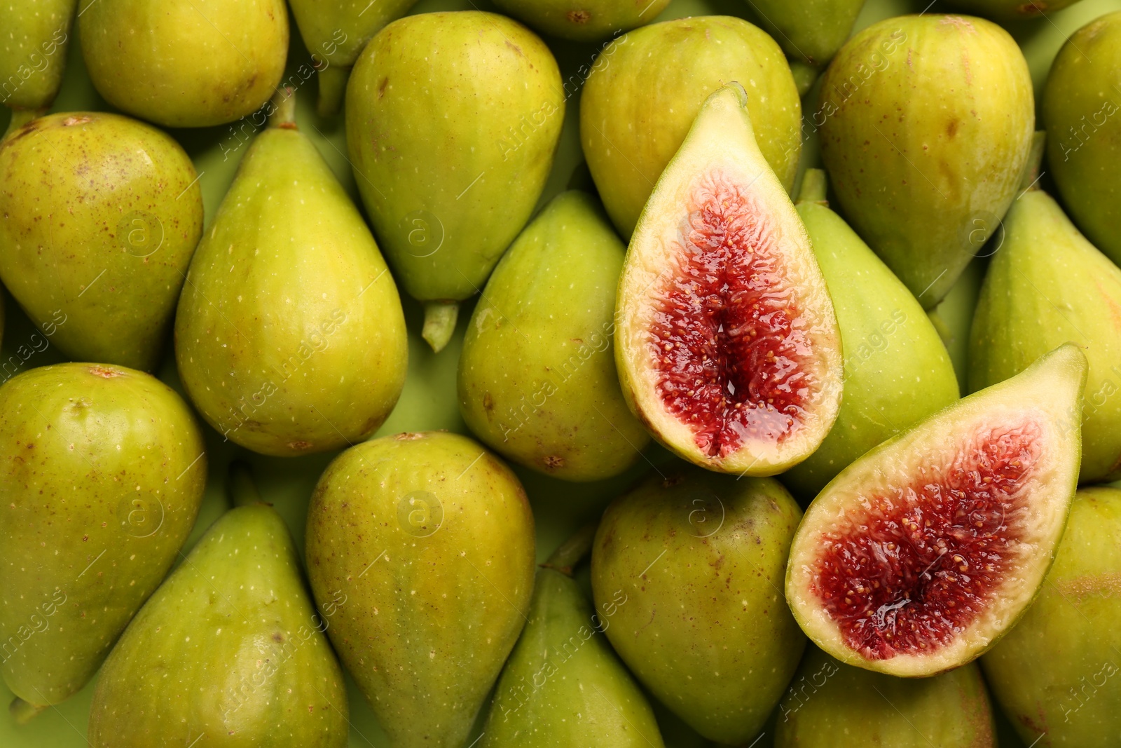 Photo of Halves of green fig on fresh fruits, top view