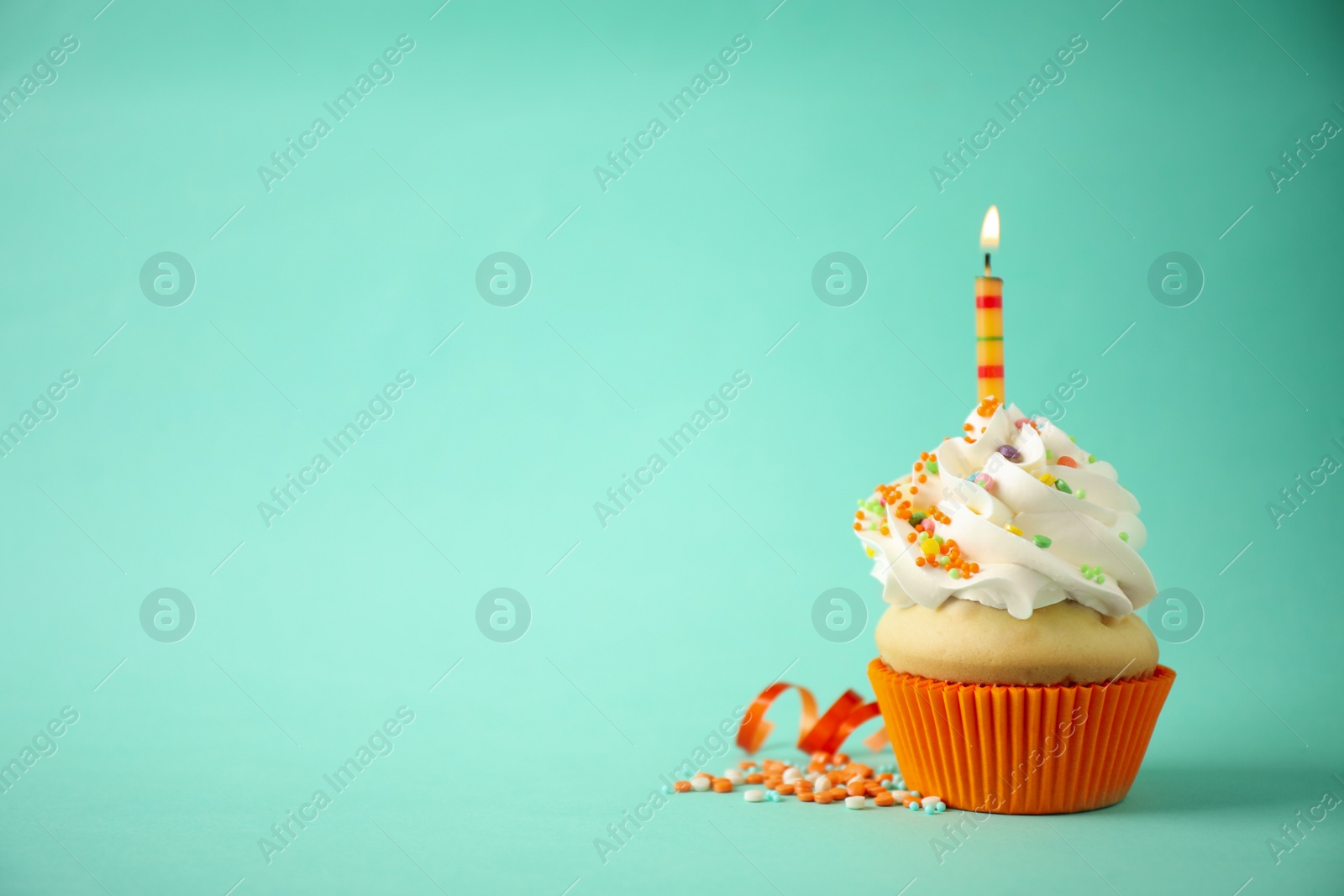 Photo of Delicious birthday cupcake with candle on light green background. Space for text