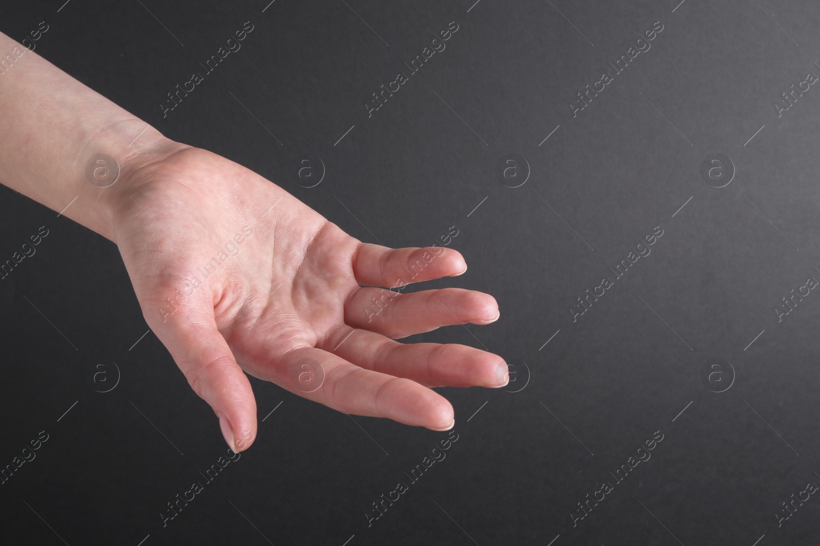 Photo of Woman holding hand on black background, closeup. Space for text