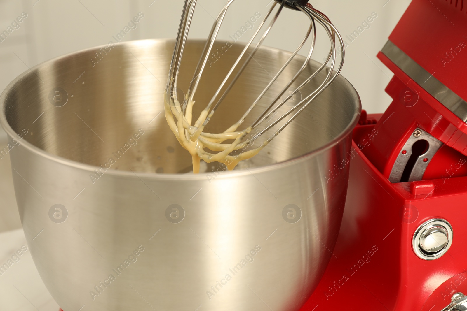 Photo of Modern red stand mixer with cream indoors, closeup