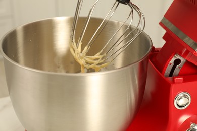 Photo of Modern red stand mixer with cream indoors, closeup