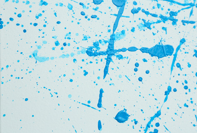 Photo of Blue paint splashes on white canvas as background. Art and creativity