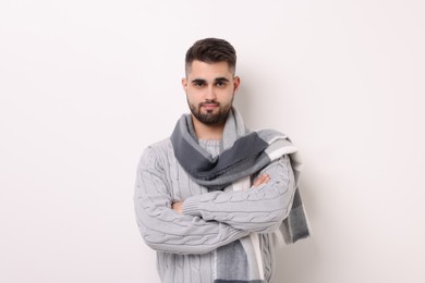 Photo of Portrait of man in warm scarf on light background
