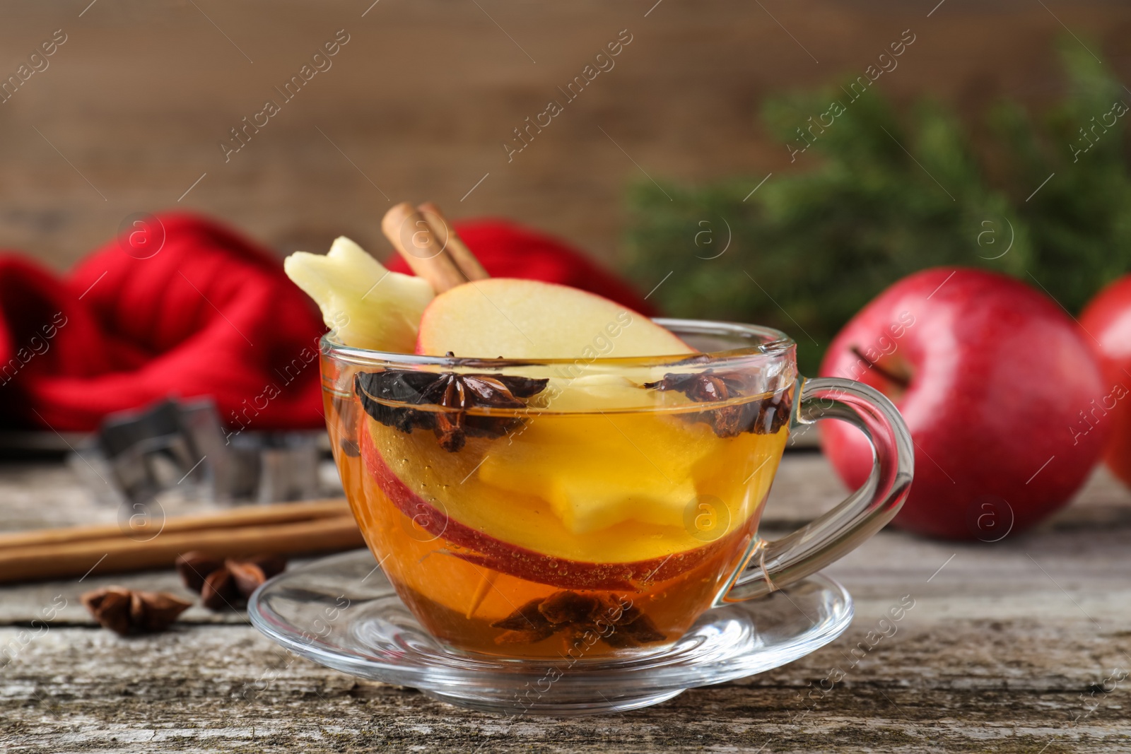 Photo of Hot mulled cider on wooden table, closeup