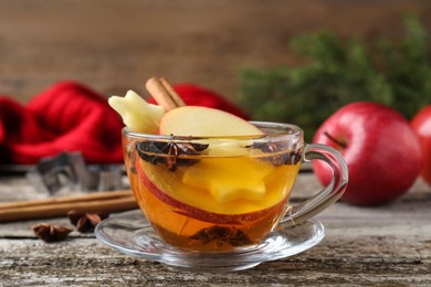 Photo of Hot mulled cider on wooden table, closeup