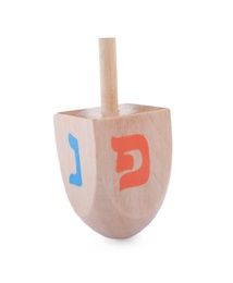 Photo of Wooden Hanukkah traditional dreidel with letters Nun and Pe isolated on white