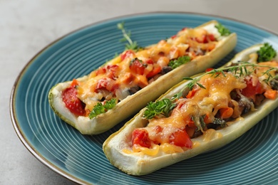 Photo of Delicious stuffed zucchini served on light grey table, closeup