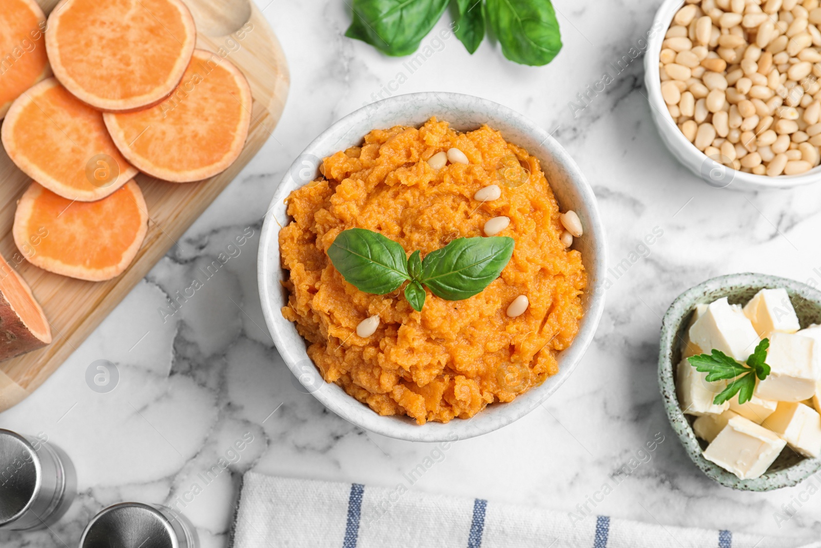 Photo of Flat lay composition with bowl of sweet potato puree and ingredients on marble table