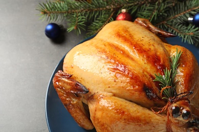 Platter of cooked turkey with Christmas decoration on grey background, closeup