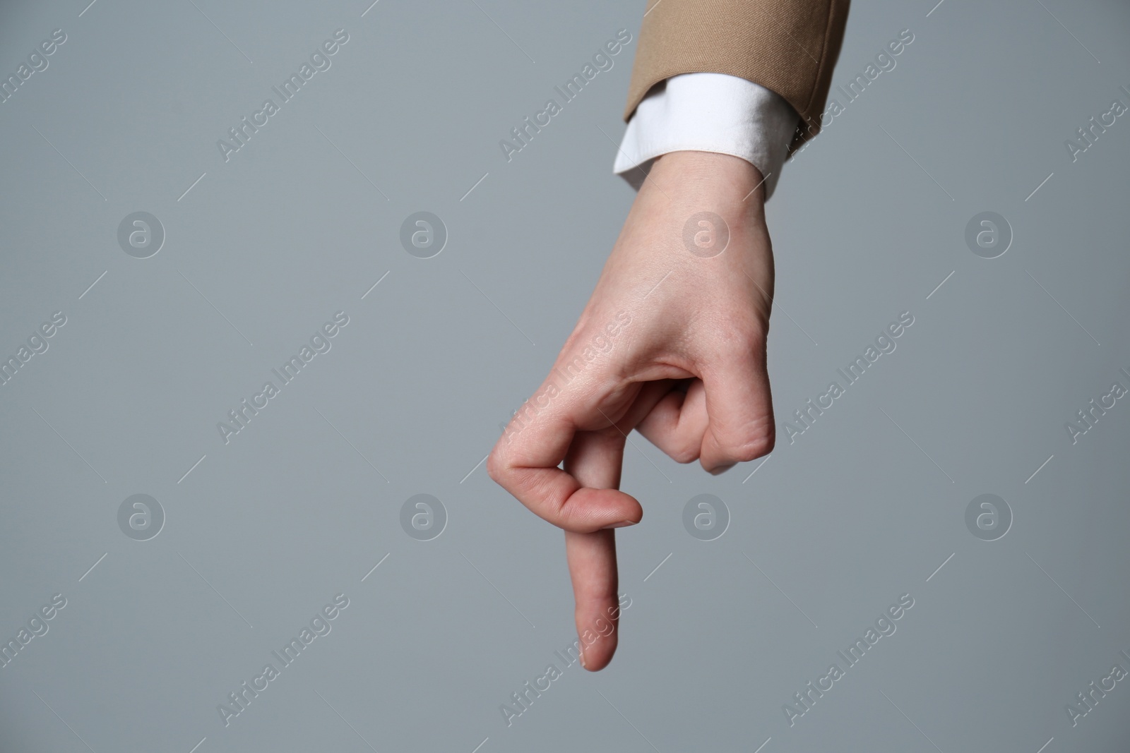 Photo of Businesswoman imitating walk with hand on grey background, closeup. Finger gesture