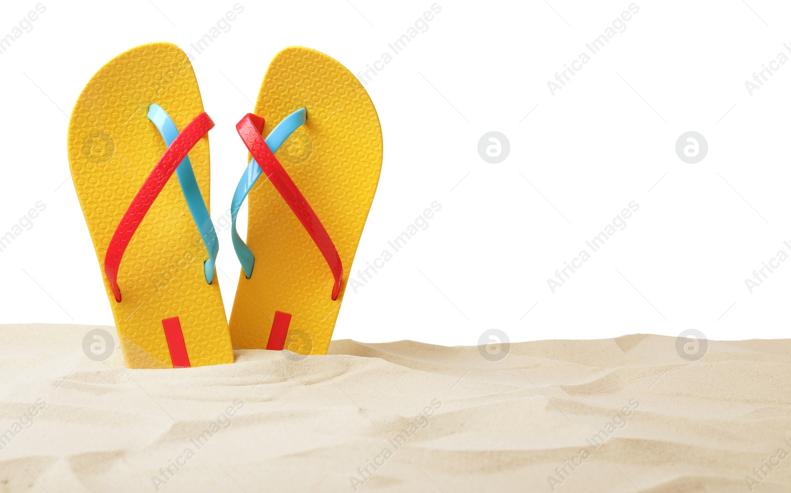 Photo of Yellow flip flops in sand on white background