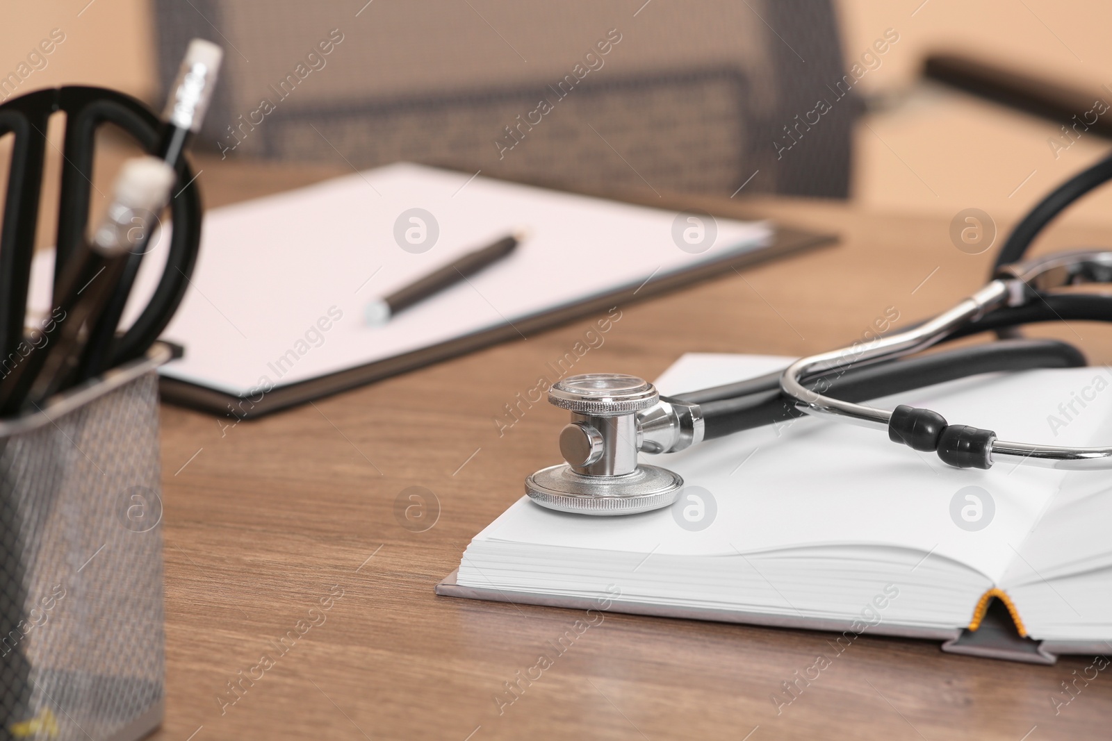 Photo of Book and stethoscope on wooden table indoors. Doctor education