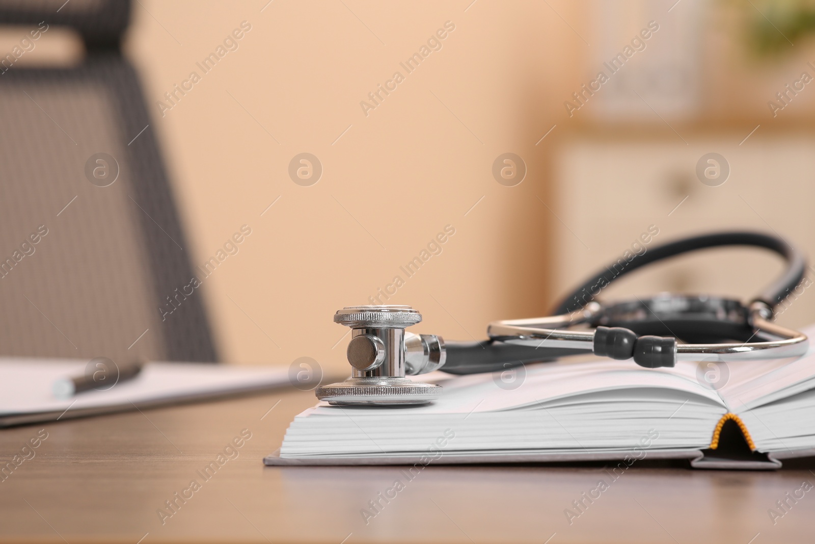 Photo of Book and stethoscope on wooden table indoors, space for text. Doctor education