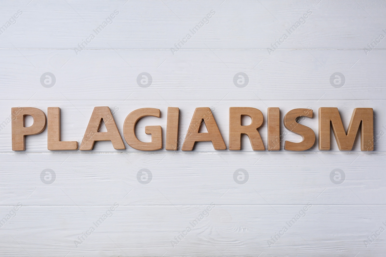 Photo of Word Plagiarism made of wooden letters on white table, flat lay