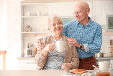 Photo of Elderly couple having breakfast in kitchen
