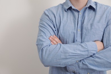 Photo of Man wearing rumpled light blue shirt on white background, closeup