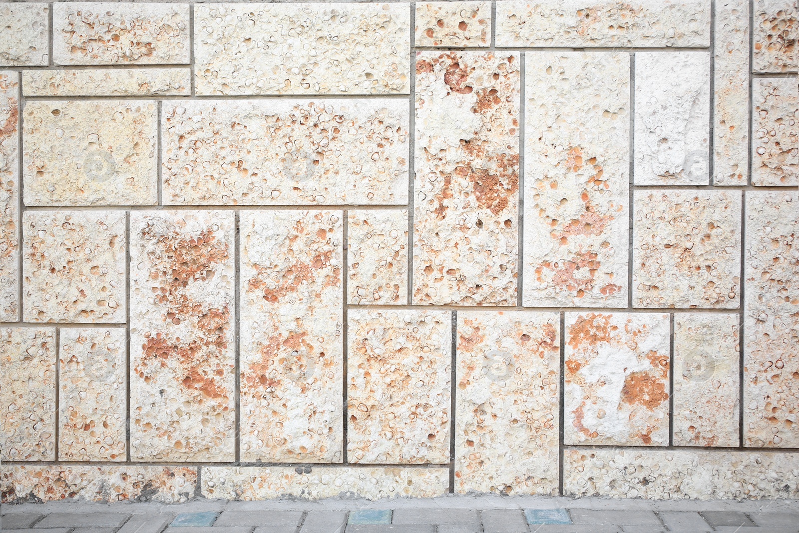 Photo of Texture of colorful brick wall near pavement outdoors