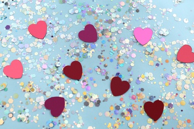 Photo of Shiny glitter on light blue background, flat lay