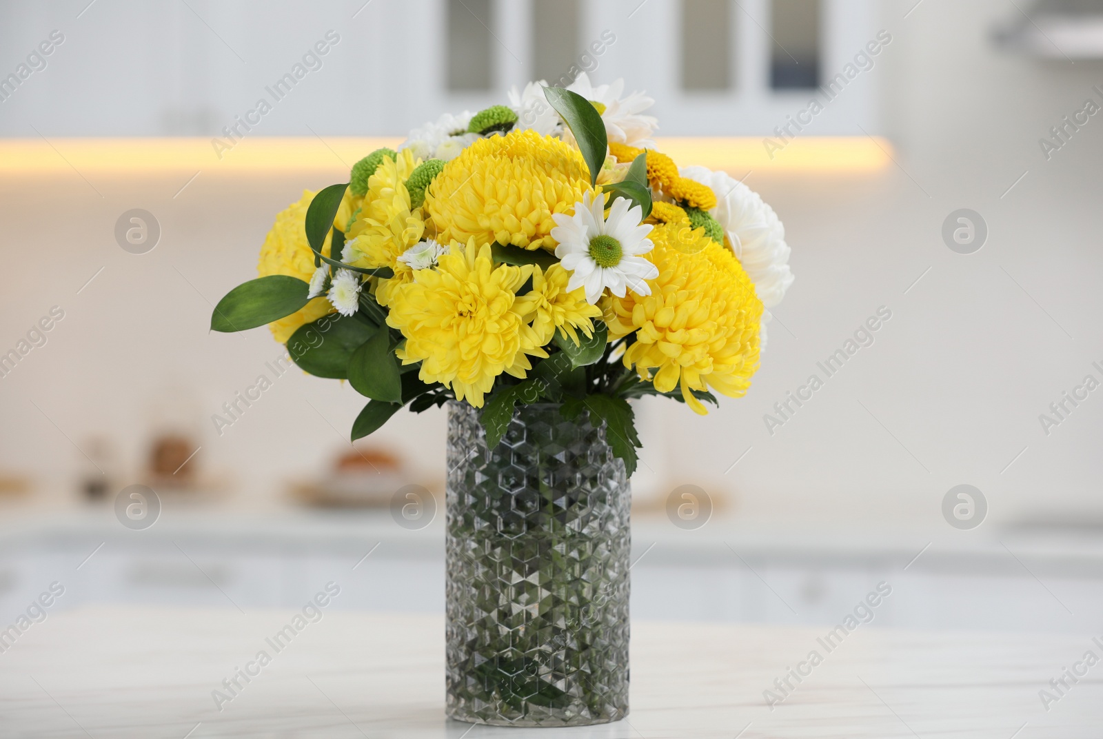 Photo of Bouquet of beautiful chrysanthemum flowers on table in kitchen