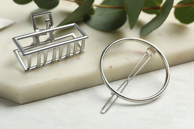 Photo of Beautiful silver hair clips on white table