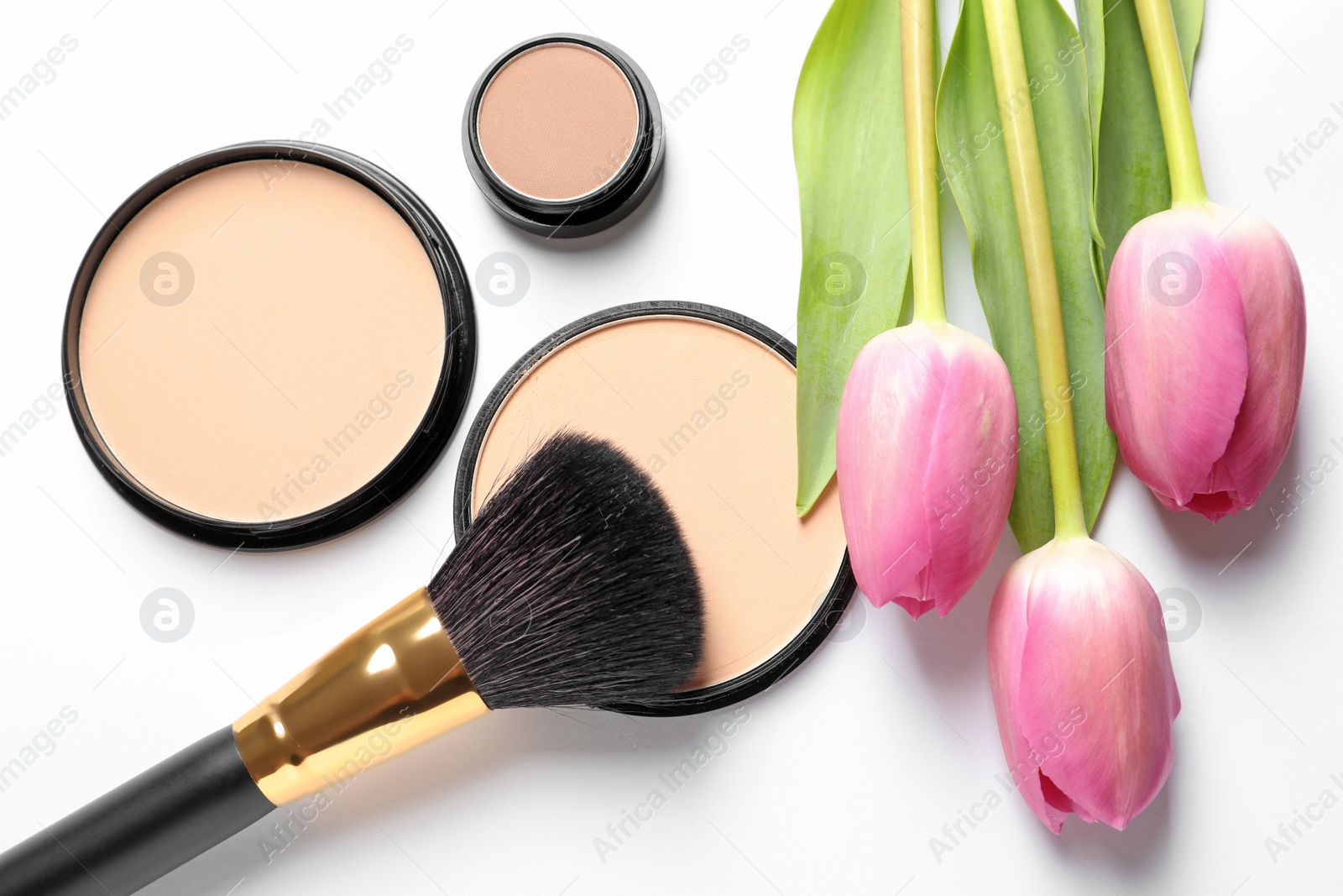 Photo of Makeup products and spring flowers on white background, top view