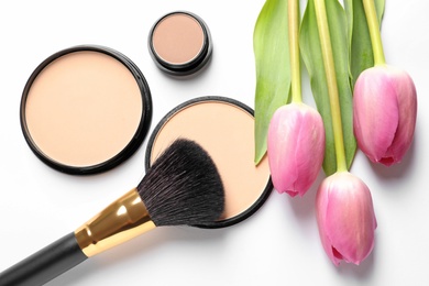 Photo of Makeup products and spring flowers on white background, top view
