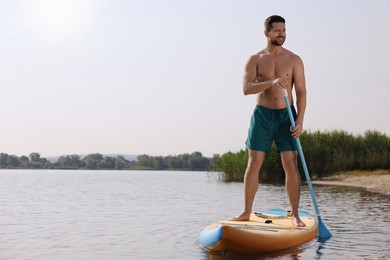 Man paddle boarding on SUP board in sea, space for text