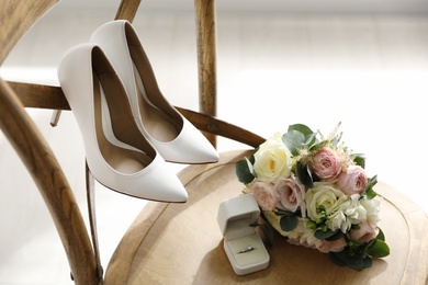 Photo of Composition with white wedding high heel shoes on wooden chair indoors
