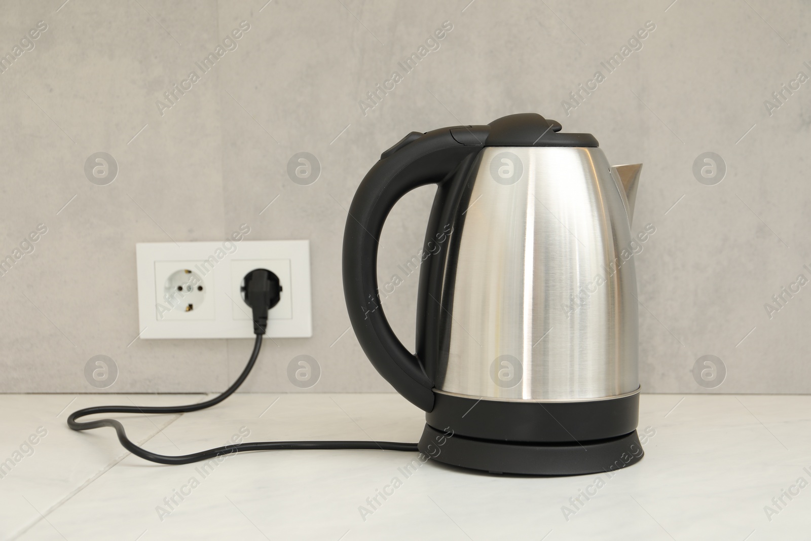 Photo of Modern electric kettle on counter in kitchen