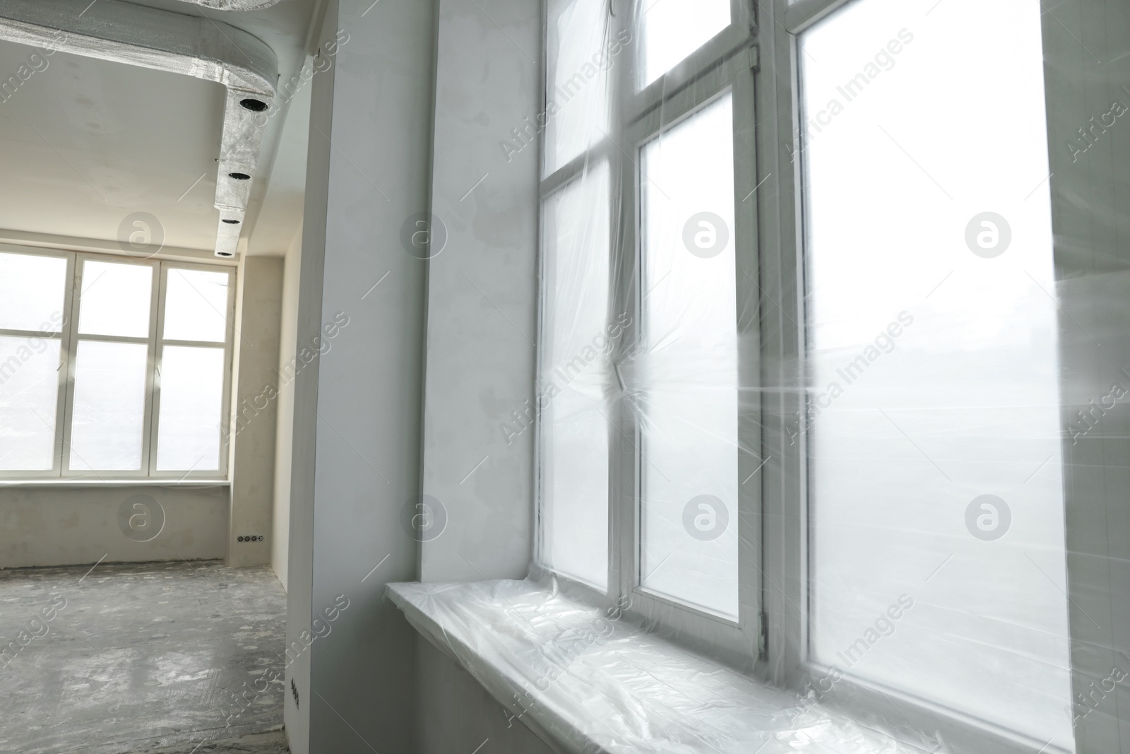 Photo of Big windows covered with plastic film in room