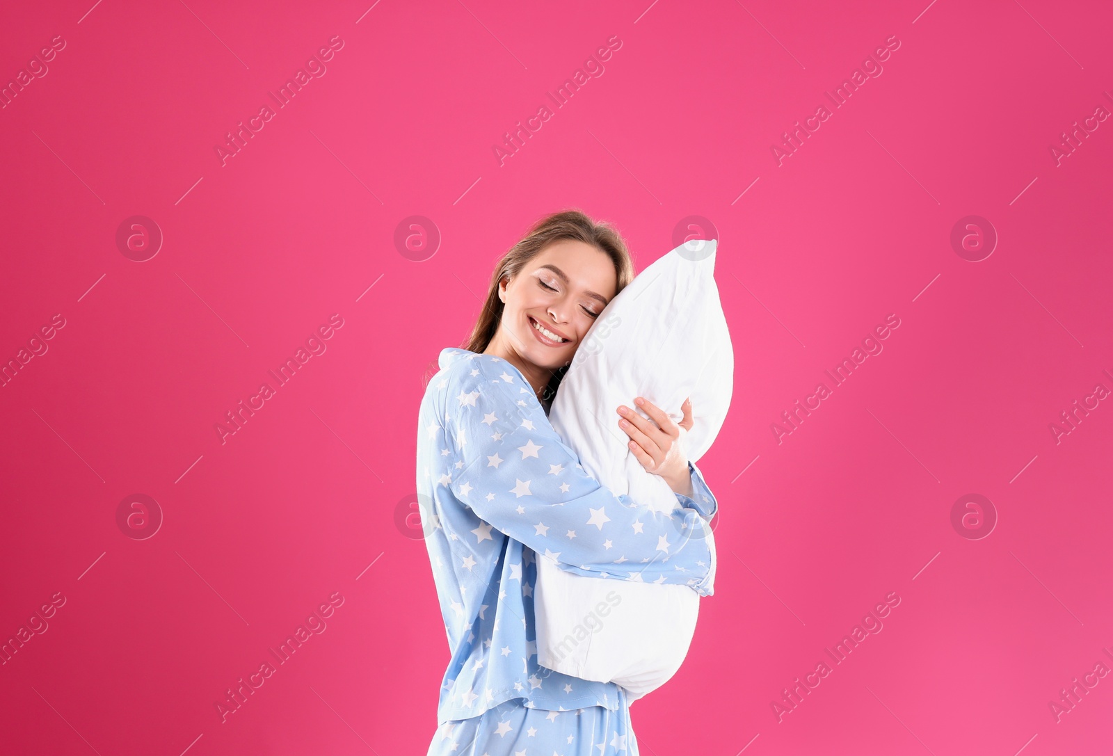 Photo of Young woman with pillow on pink background