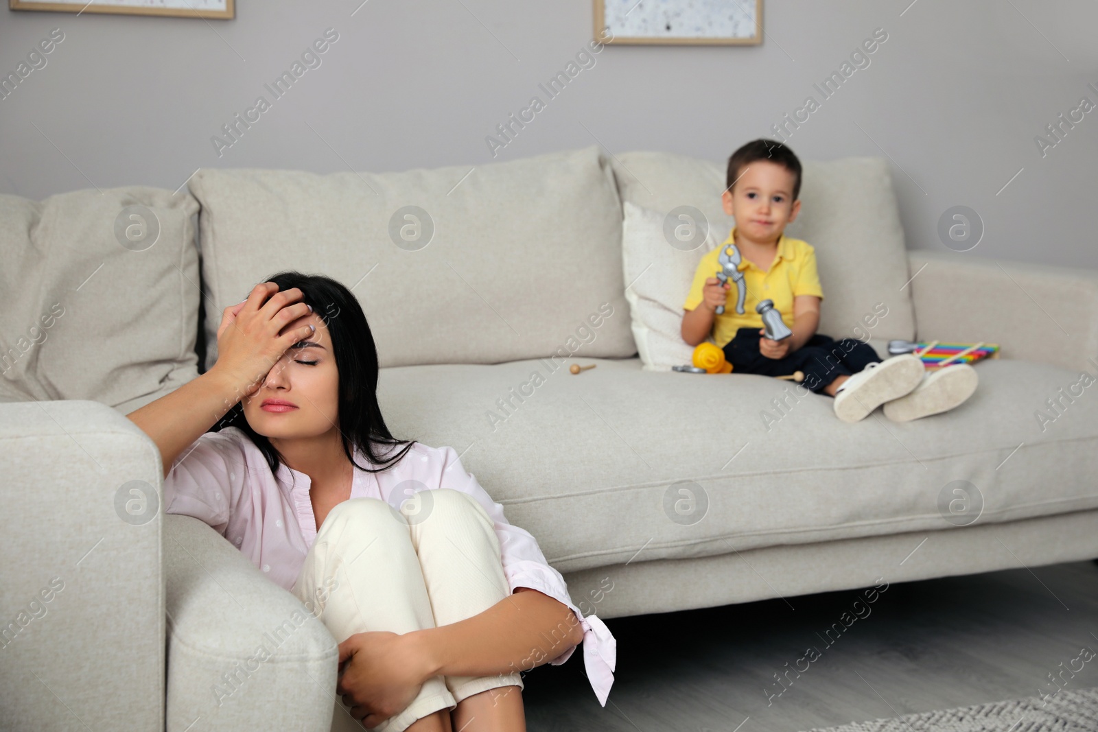 Photo of Depressed single mother with child in living room