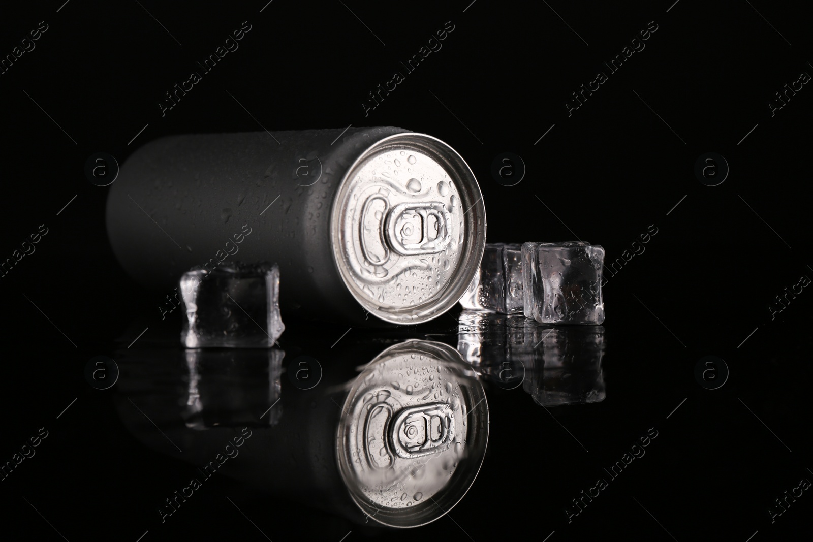 Photo of Energy drink in wet can and ice cubes on black background