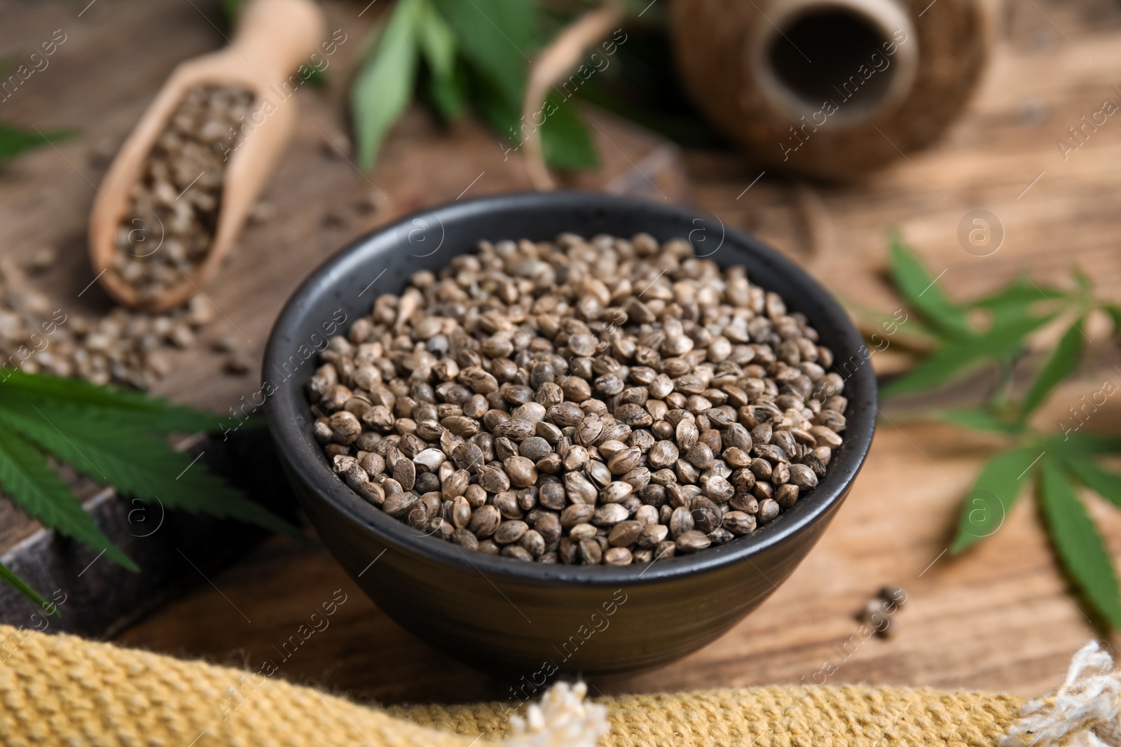 Photo of Bowl with hemp seeds on wooden table, closeup