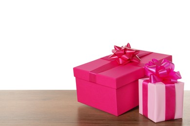 Pink gift boxes on wooden table against white background, space for text