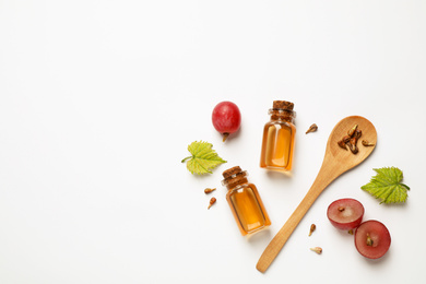 Photo of Composition with bottles of natural grape seed oil on white background, top view. Organic cosmetic