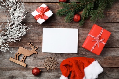 Photo of Flat lay composition with empty card and Christmas decoration on wooden background. Writing letter to Santa Claus