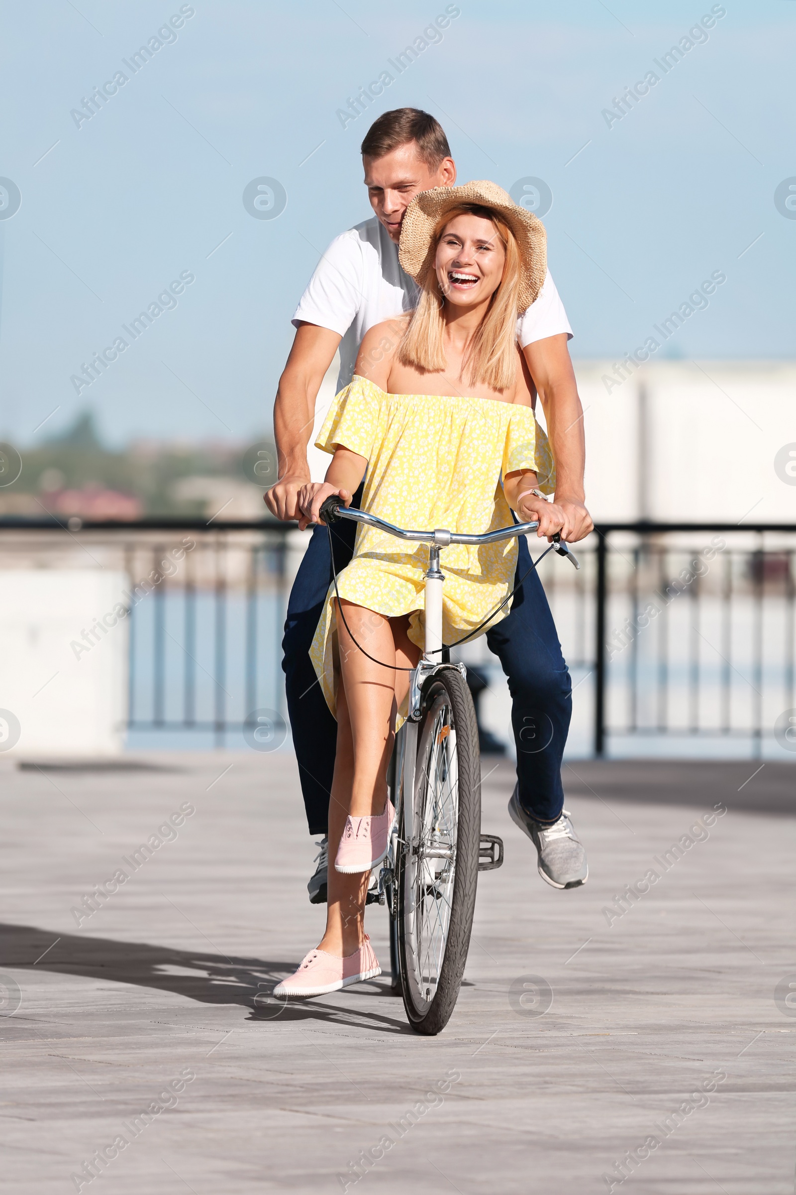 Photo of Happy couple riding bicycle outdoors on sunny day
