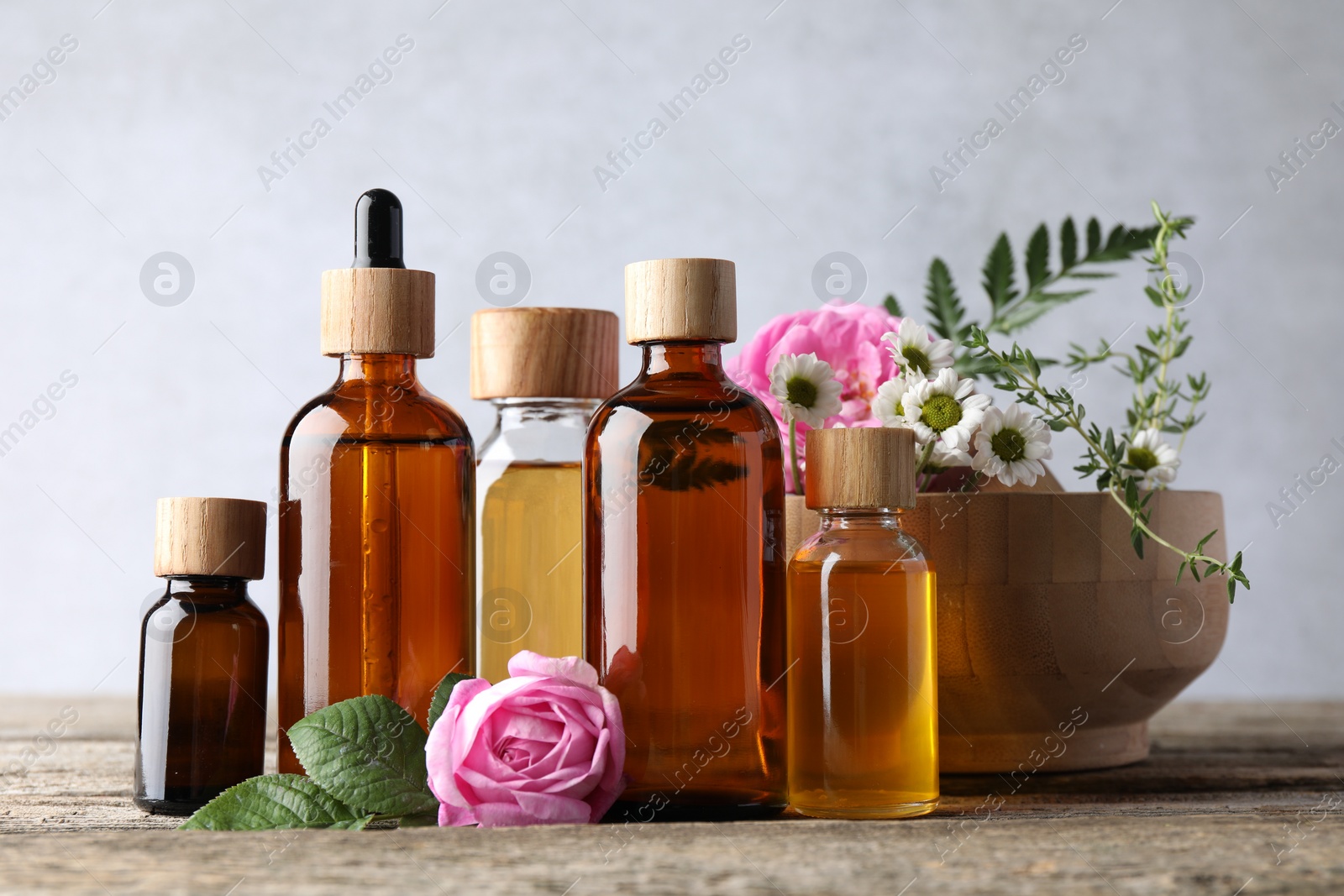 Photo of Aromatherapy. Different essential oils and flowers on wooden table